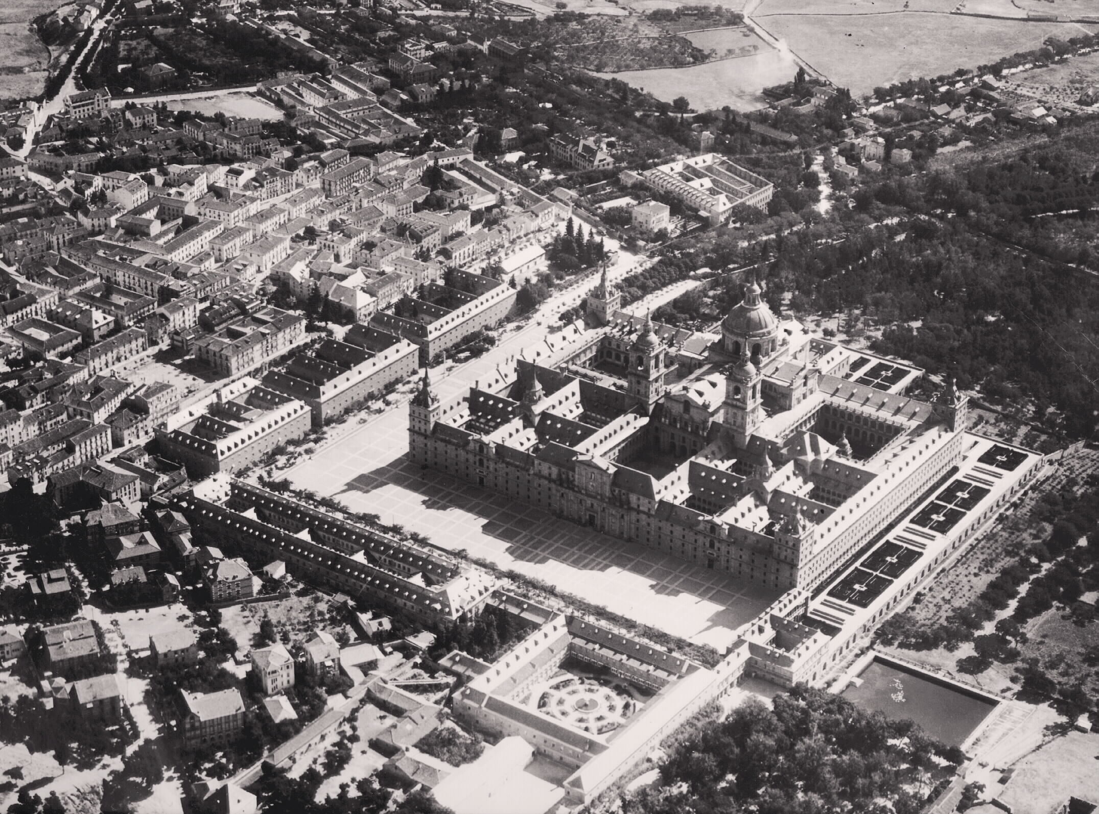 Vista aérea del Monasterio de El escorial en donde se aprecian a la perfección las tres Casas de Oficios y la Casa de Infantes. 1929.